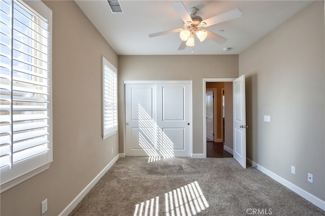 unfurnished bedroom featuring baseboards, visible vents, a closet, and carpet flooring