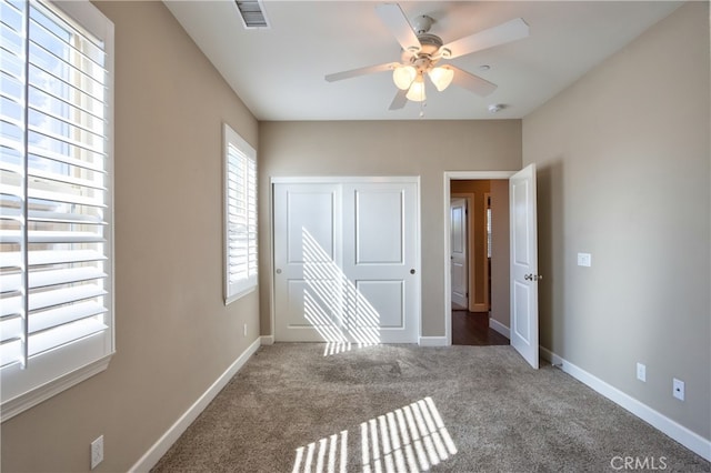 unfurnished bedroom featuring baseboards, visible vents, carpet, and a closet