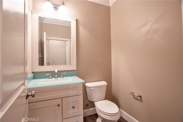 half bathroom with toilet, baseboards, wood finished floors, and vanity