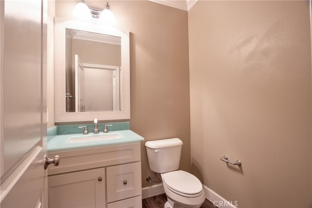 bathroom with vanity, crown molding, and toilet