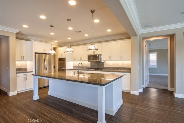 kitchen with a center island with sink, visible vents, white cabinets, stainless steel appliances, and a sink