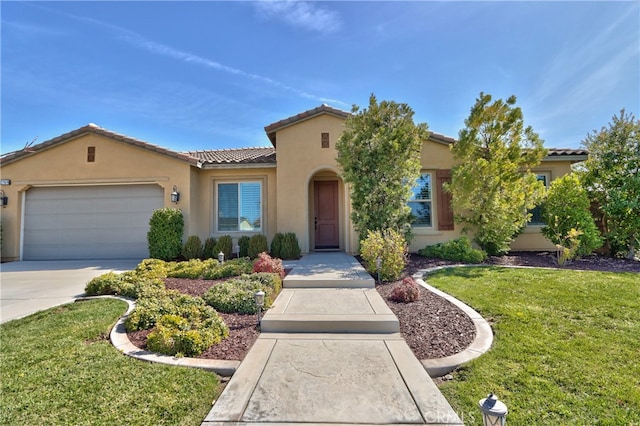 mediterranean / spanish home with a garage, a front lawn, stucco siding, and a tile roof