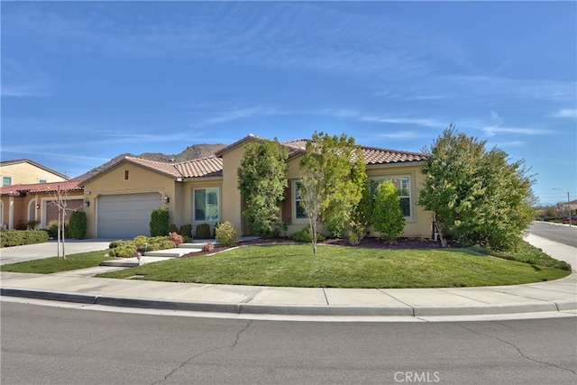 mediterranean / spanish house with a garage, concrete driveway, a tiled roof, stucco siding, and a front yard