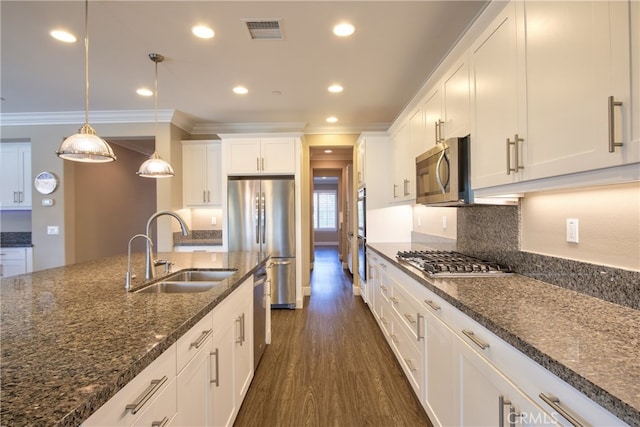 kitchen featuring a sink, stainless steel appliances, dark wood-type flooring, visible vents, and ornamental molding