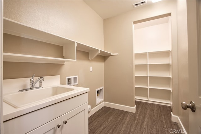 laundry area featuring dark wood-style floors, washer hookup, visible vents, cabinet space, and a sink