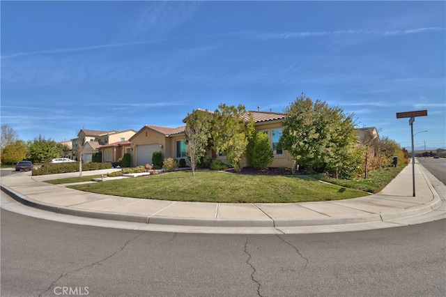 view of front facade featuring a tile roof, a garage, a front lawn, concrete driveway, and stucco siding