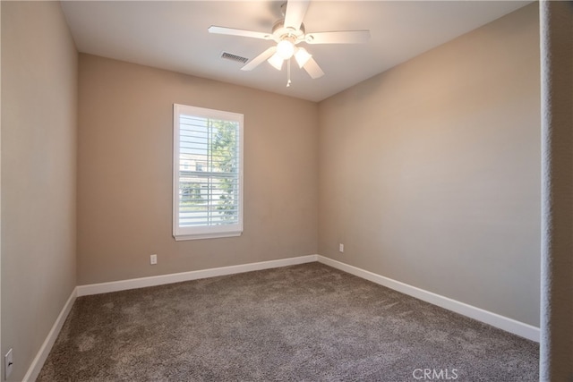 empty room with dark colored carpet, visible vents, and baseboards