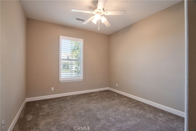 empty room with baseboards, a ceiling fan, dark carpet, and visible vents