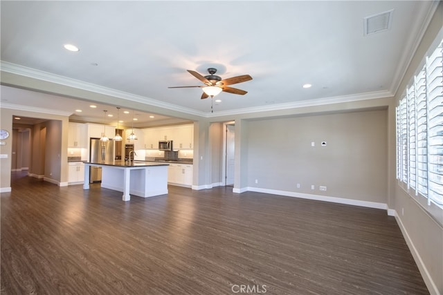 unfurnished living room featuring a ceiling fan, visible vents, a sink, ornamental molding, and dark wood-type flooring