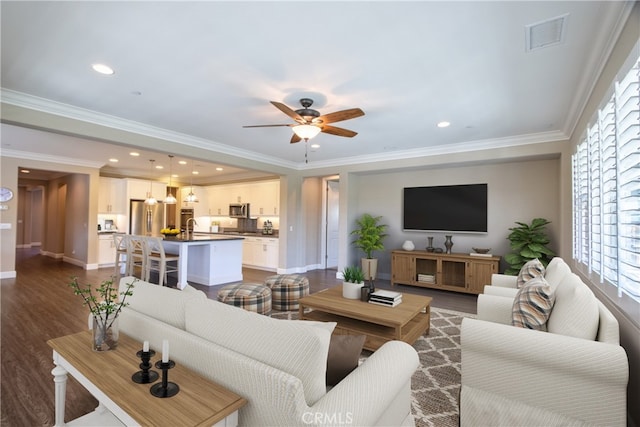 living room featuring baseboards, visible vents, dark wood finished floors, and ornamental molding