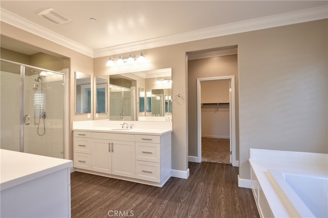 bathroom featuring a shower stall, visible vents, wood finished floors, and ornamental molding