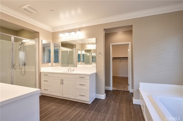 bathroom with vanity, wood finished floors, visible vents, ornamental molding, and a stall shower