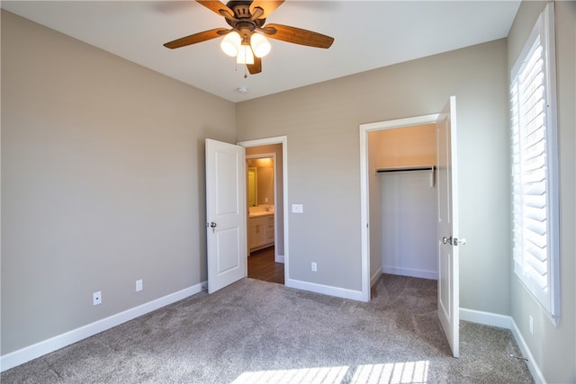 unfurnished bedroom featuring carpet floors, a closet, ceiling fan, and baseboards