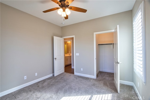 unfurnished bedroom featuring baseboards, multiple windows, carpet, and a closet