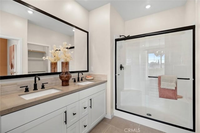 bathroom with a shower stall, tile patterned flooring, double vanity, and decorative backsplash
