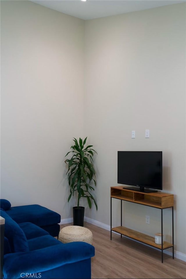 living area featuring baseboards and wood finished floors