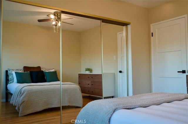 bedroom with a closet, a ceiling fan, and wood finished floors