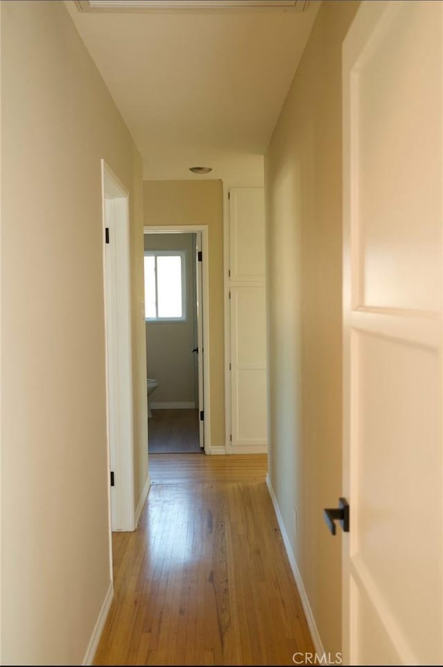 hallway with baseboards and light wood finished floors