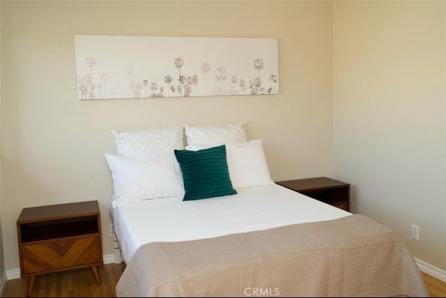 bedroom with baseboards and wood finished floors