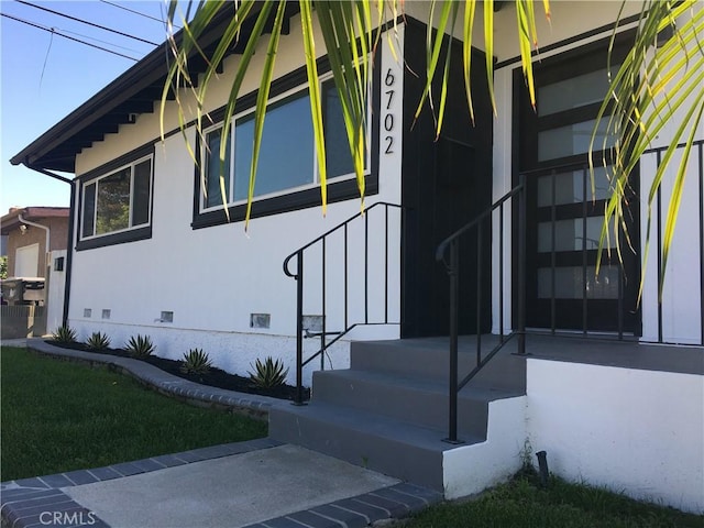 view of side of home with crawl space and stucco siding