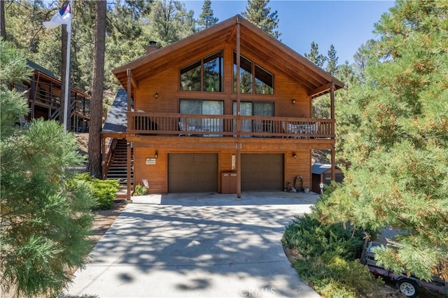 chalet / cabin with a chimney, driveway, stairway, and an attached garage