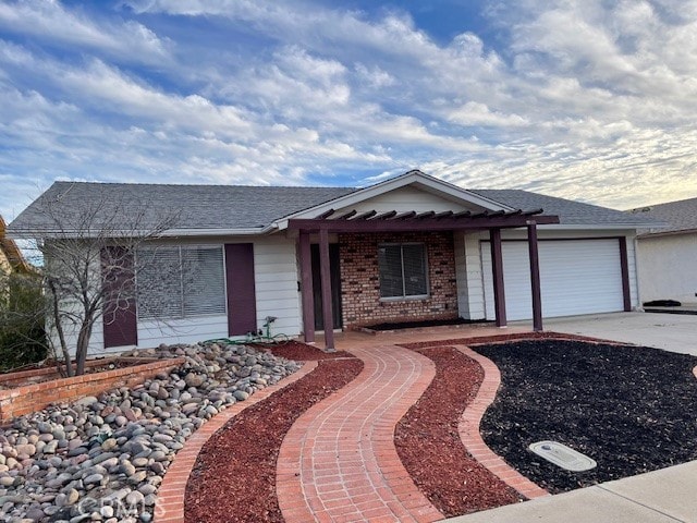 ranch-style home featuring concrete driveway, brick siding, and an attached garage