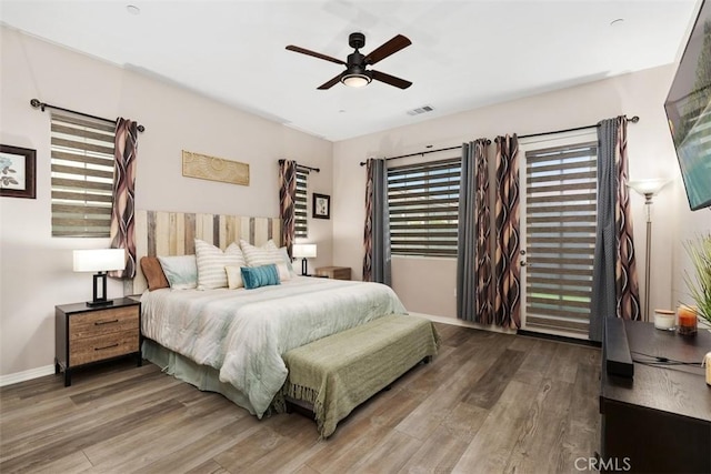bedroom featuring multiple windows, wood finished floors, and visible vents