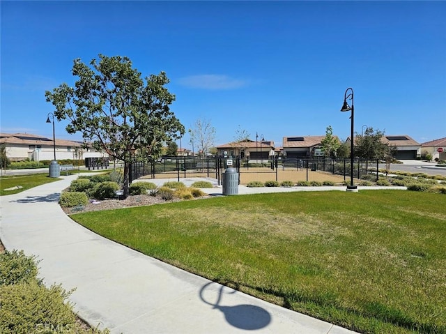 view of home's community featuring a lawn and fence