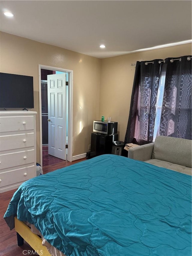 bedroom with dark wood-type flooring and recessed lighting