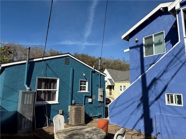 view of side of property with central AC and stucco siding