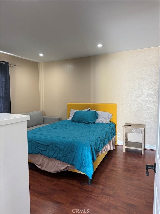 bedroom with baseboards, wood finished floors, and recessed lighting