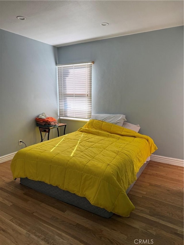 bedroom with baseboards and wood finished floors