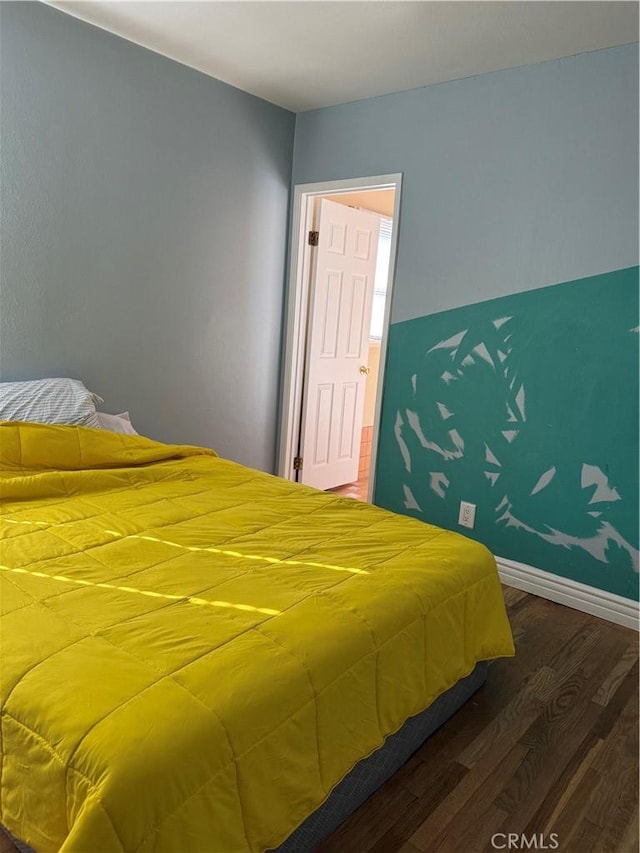 bedroom featuring wood finished floors and baseboards