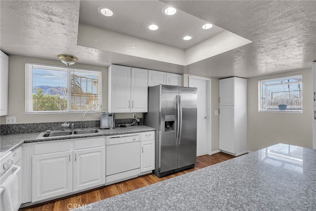 kitchen with stainless steel fridge with ice dispenser, a sink, wood finished floors, range, and dishwasher