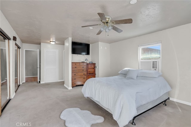 bedroom with light carpet, cooling unit, baseboards, and a ceiling fan