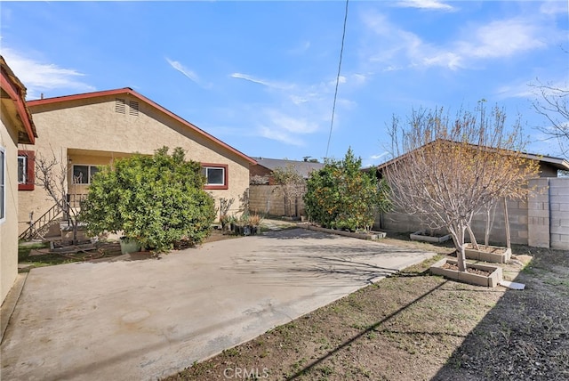 exterior space featuring a garden and fence