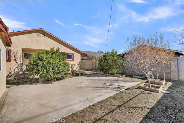 view of yard featuring a vegetable garden, fence, and a patio area