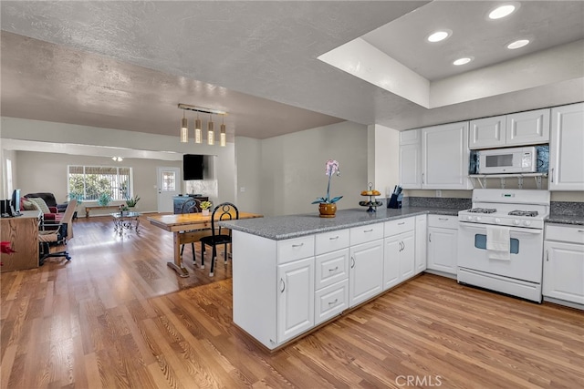 kitchen featuring light wood-style flooring, a peninsula, white appliances, white cabinetry, and open floor plan