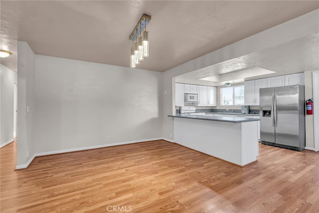 kitchen with white cabinets, light wood-style flooring, a peninsula, stainless steel refrigerator with ice dispenser, and white microwave