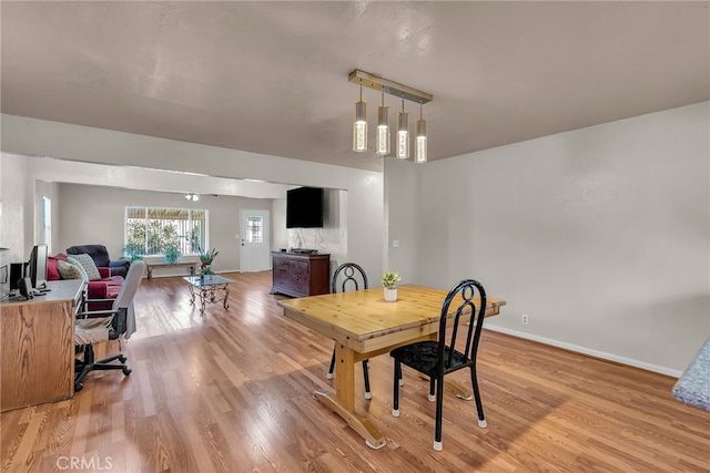 dining room with baseboards and light wood-type flooring
