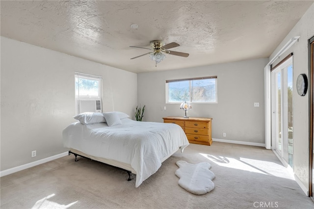 bedroom featuring a textured ceiling, light carpet, and baseboards