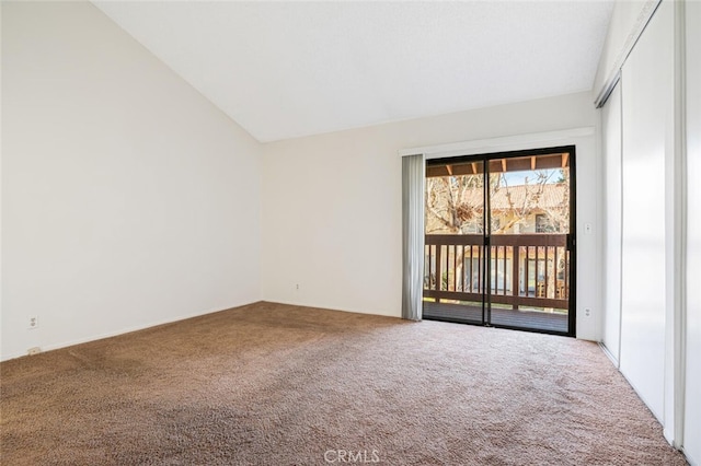 carpeted spare room with lofted ceiling