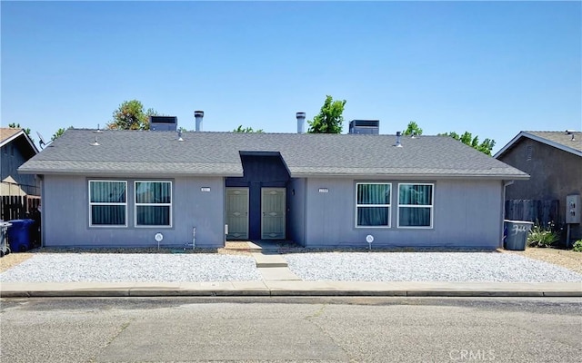 ranch-style home with roof with shingles, a chimney, and central air condition unit