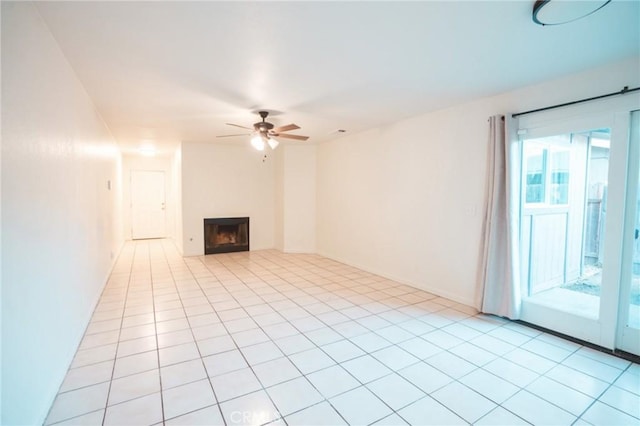 unfurnished living room with light tile patterned floors, ceiling fan, and a fireplace