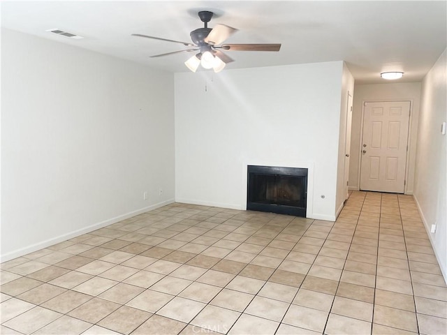 spare room featuring visible vents, a fireplace, baseboards, and ceiling fan