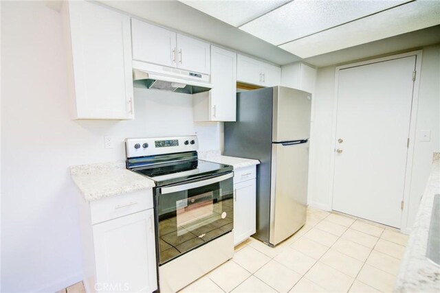 kitchen featuring light tile patterned floors, appliances with stainless steel finishes, white cabinets, and under cabinet range hood