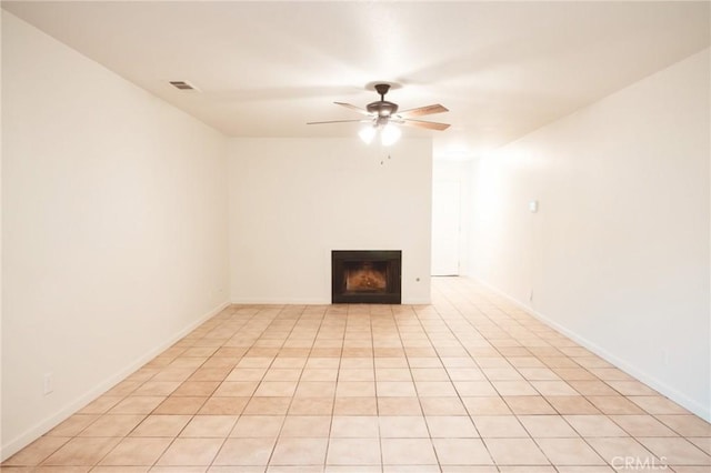 unfurnished living room with ceiling fan, a fireplace, visible vents, and baseboards