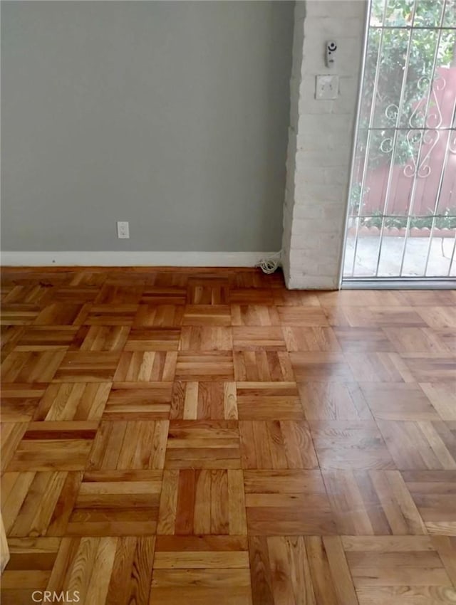 empty room featuring plenty of natural light and baseboards