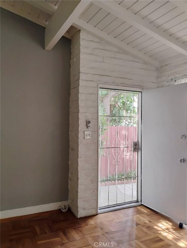 doorway featuring vaulted ceiling with beams and baseboards