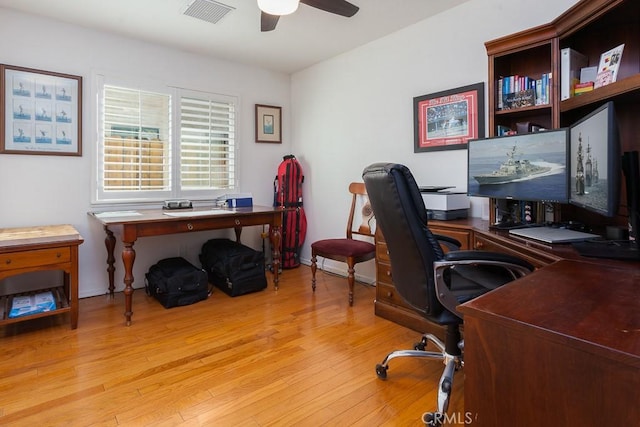 home office with a ceiling fan, baseboards, visible vents, and wood finished floors